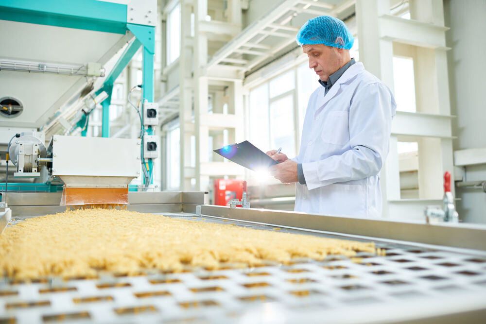 worker inspecting food at a food processing plant